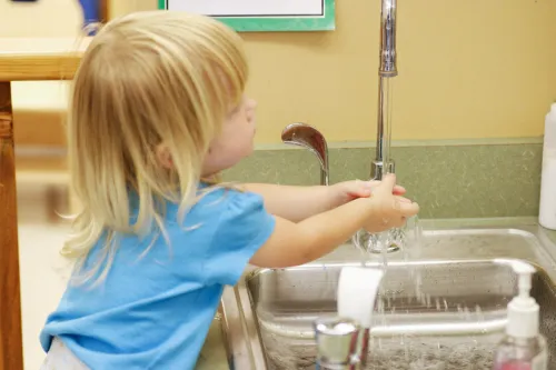 blonde boy washing his hands